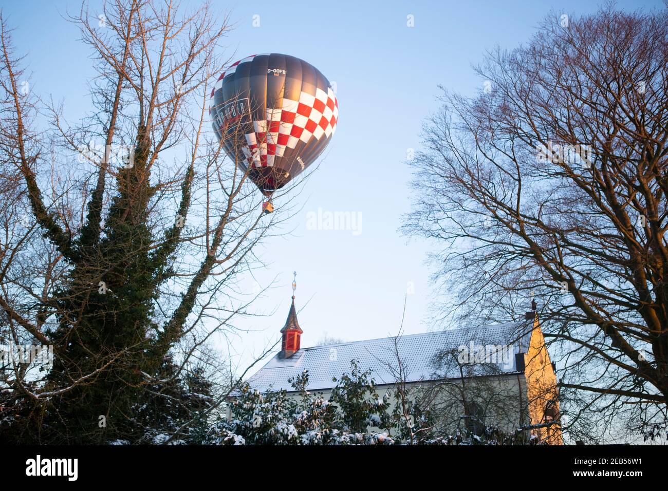 Heissluftballon über den verschneiten Wiesen bei Willich in den Nachmittagsstunden. Stock Photo