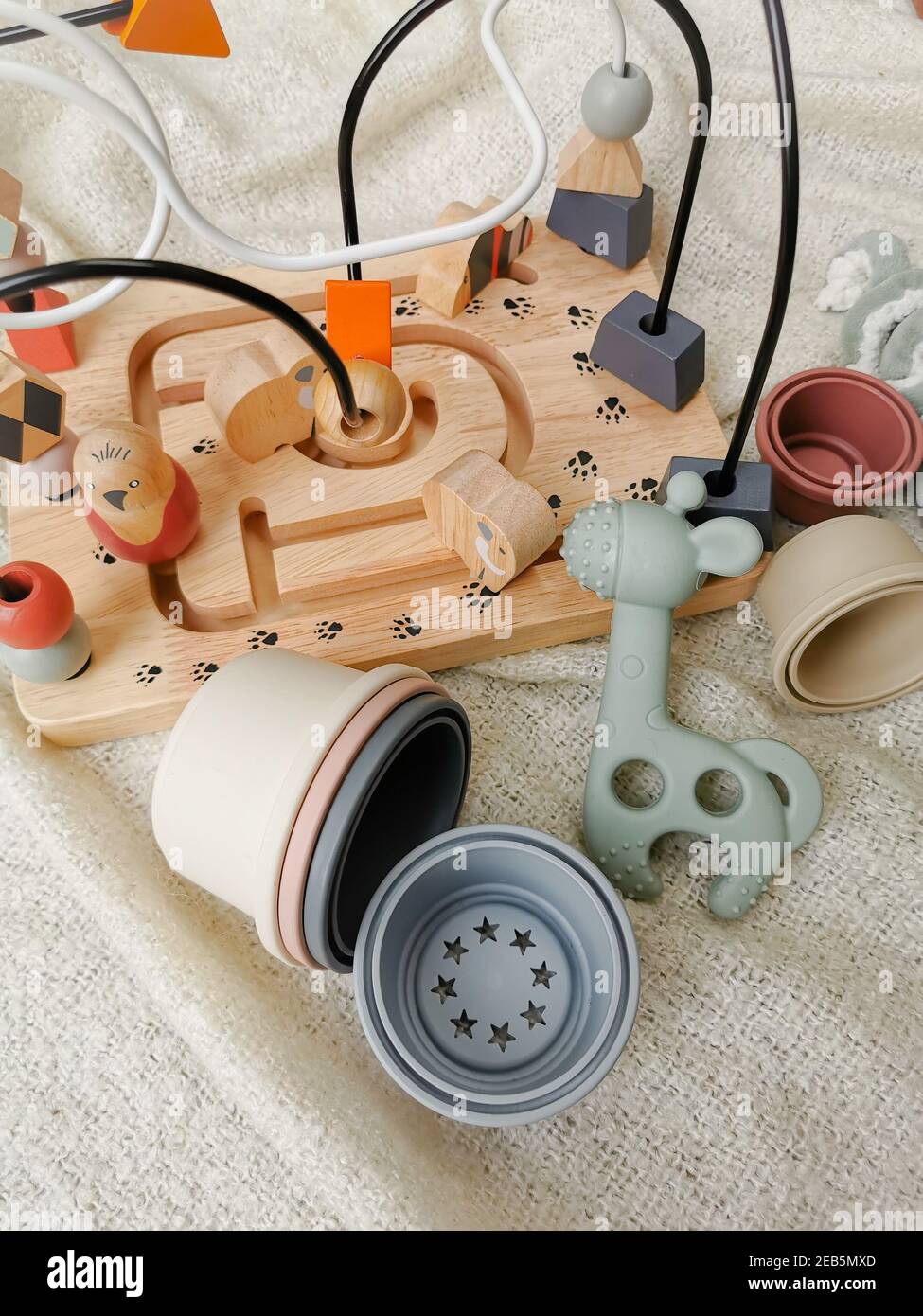 Gender neutral toys for babies in muted soft colors. Wooden blocks en bead frame, teething toy, ... Gender-neutral parenting. Stock Photo