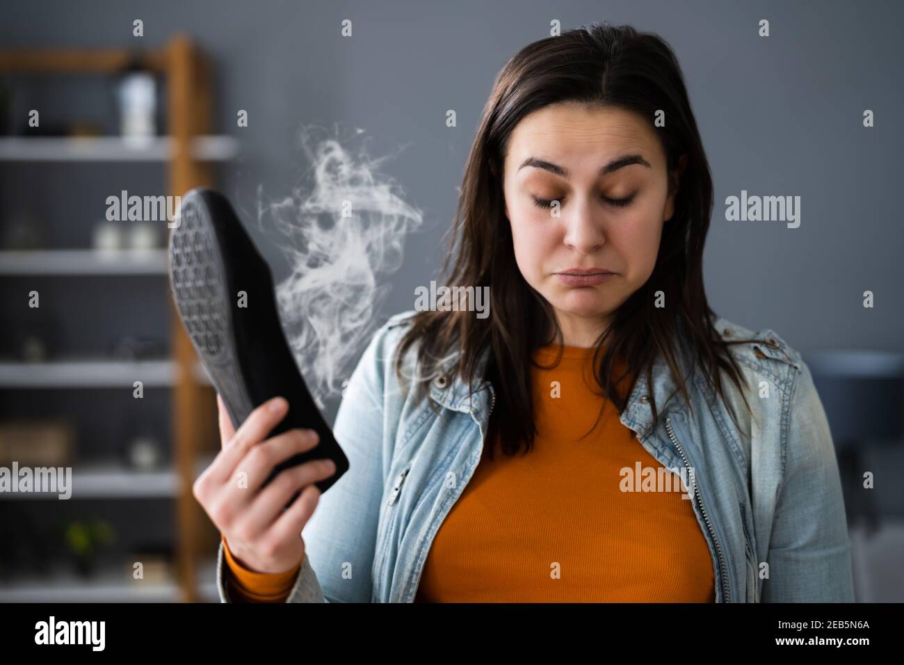 Woman Smelling Stinky Shoes. Feet Sweat And Odor Stock Photo