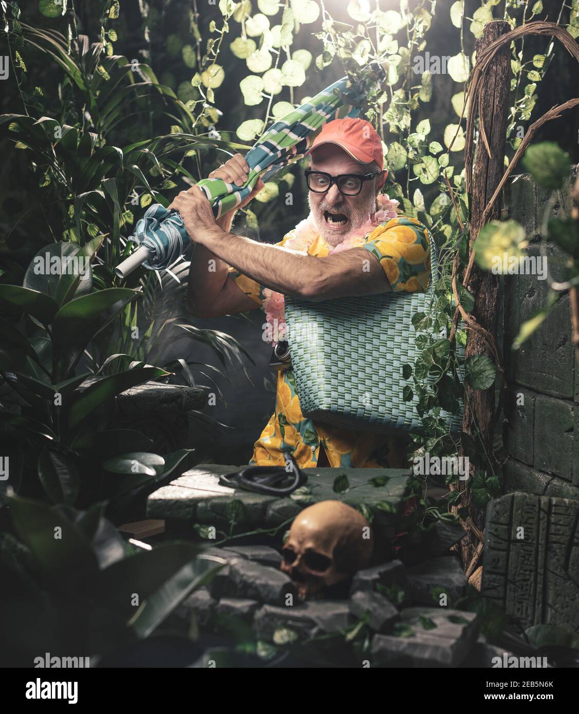 Angry tourist trying to kill a snake in the jungle using a beach umbrella Stock Photo