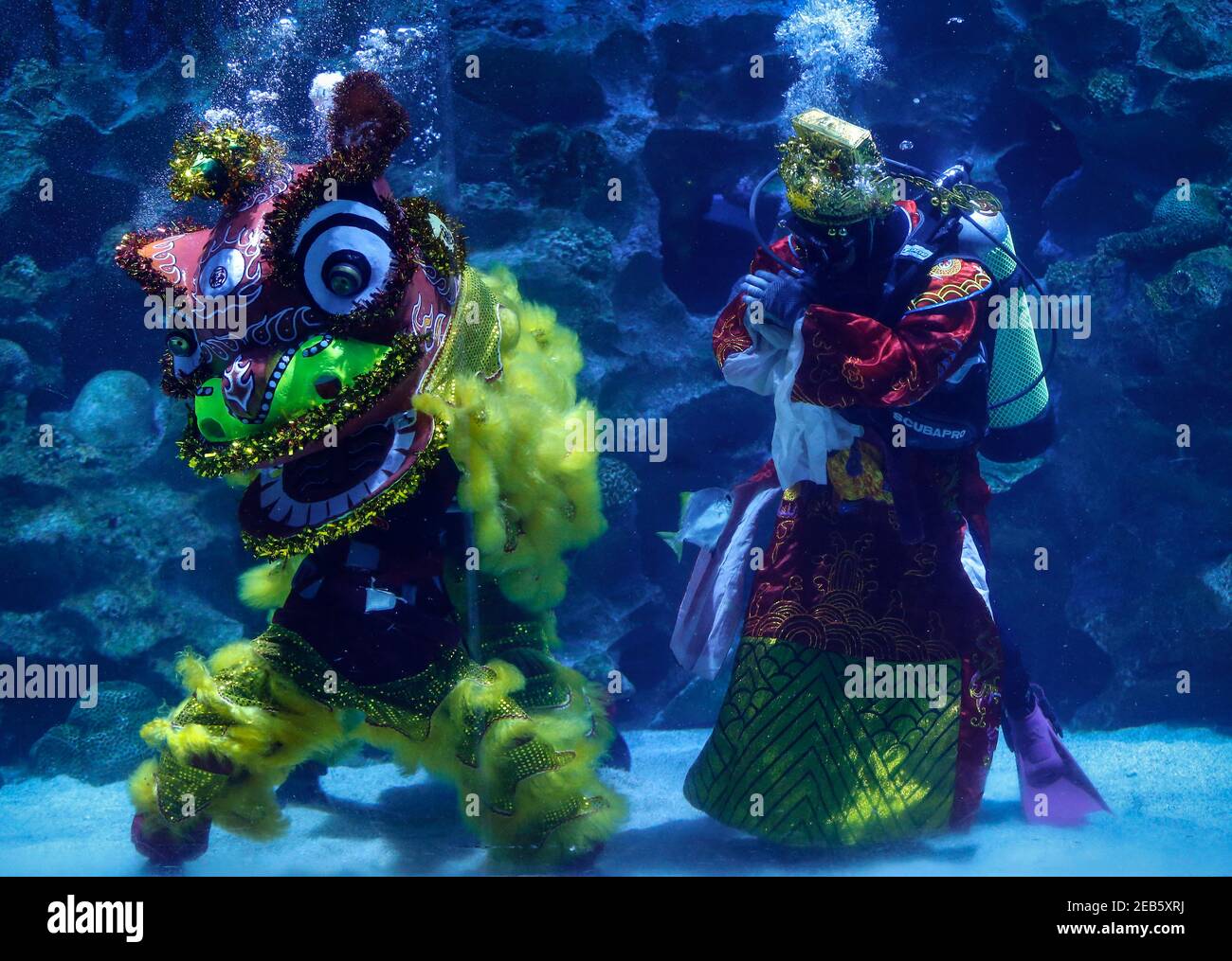 Kuala Lumpur, Malaysia. 12th Feb, 2021. Divers perform the lion dance at the Aquaria KLCC during the Lunar New Year celebrations.Chinese around the world will be celebrating the Chinese Lunar New Year and welcome the year of Ox which falls on February 12, 2021. Credit: SOPA Images Limited/Alamy Live News Stock Photo
