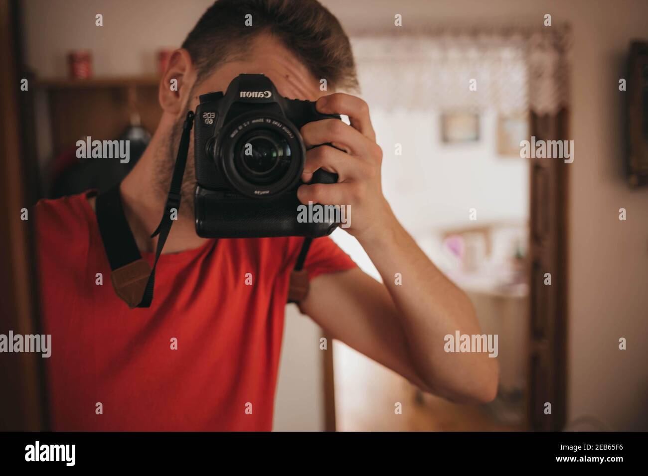BRCKO, BOSNIA AND HERZEGOVINA - Oct 16, 2019: Man in red shirt taking selfportrait in mirror with Canon 6D Stock Photo