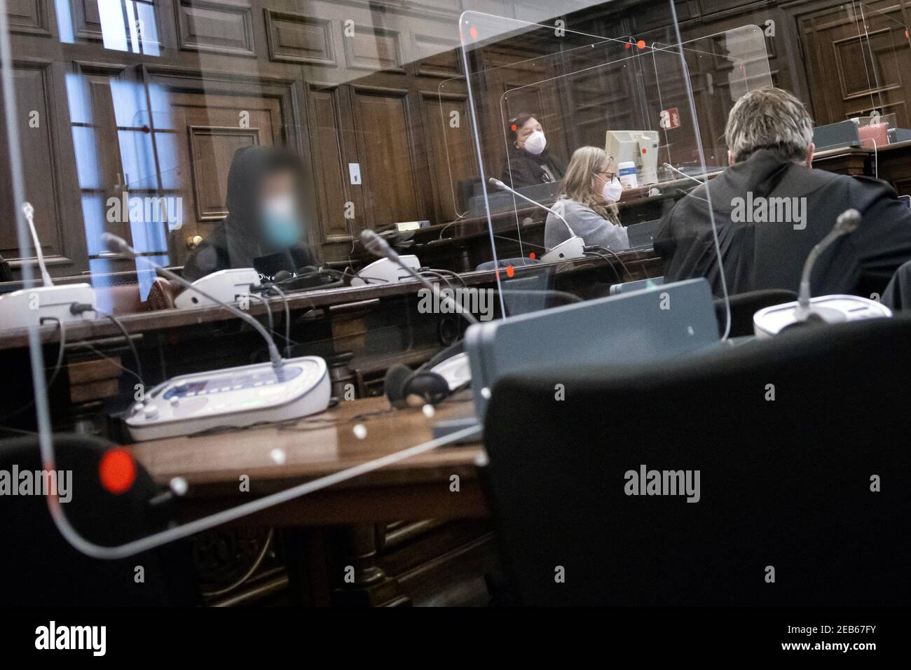 12 February 2021, Hamburg: The 29-year-old defendant (l), his lawyer Fabian Hellweg (r) and other participants in the trial sit in the courtroom in the Criminal Justice Building before the start of the safeguarding proceedings. A good four months after the attack on a Jewish student outside the Hamburg synagogue, the trial of the alleged perpetrator began on Friday. According to a psychiatric report, the German citizen, who was born in Kazakhstan, is incapable of guilt. Photo: Christian Charisius/dpa/Pool/dpa - ATTENTION: Person(s) have been pixelated for legal reasons Stock Photo