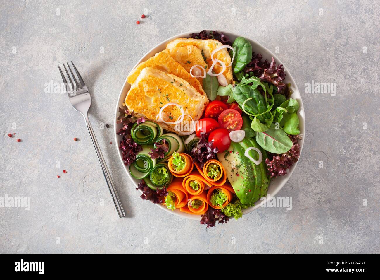 ketogenic paleo diet lunch bowl. halloumi cheese, avocado carrot cucumber salad leaves Stock