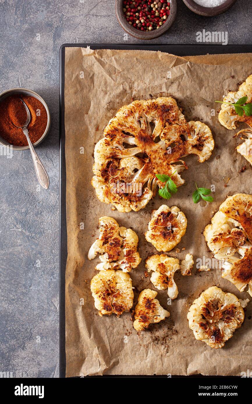cauliflower steaks with herb and spice on baking tray. plant based meat substitute Stock Photo