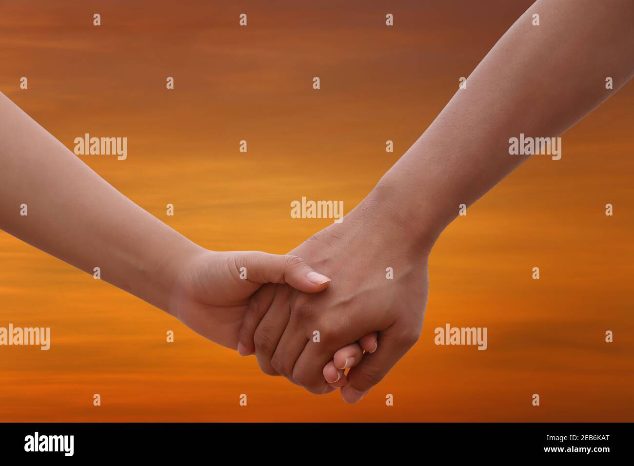 Young people holding hands on twilight sky background for design in