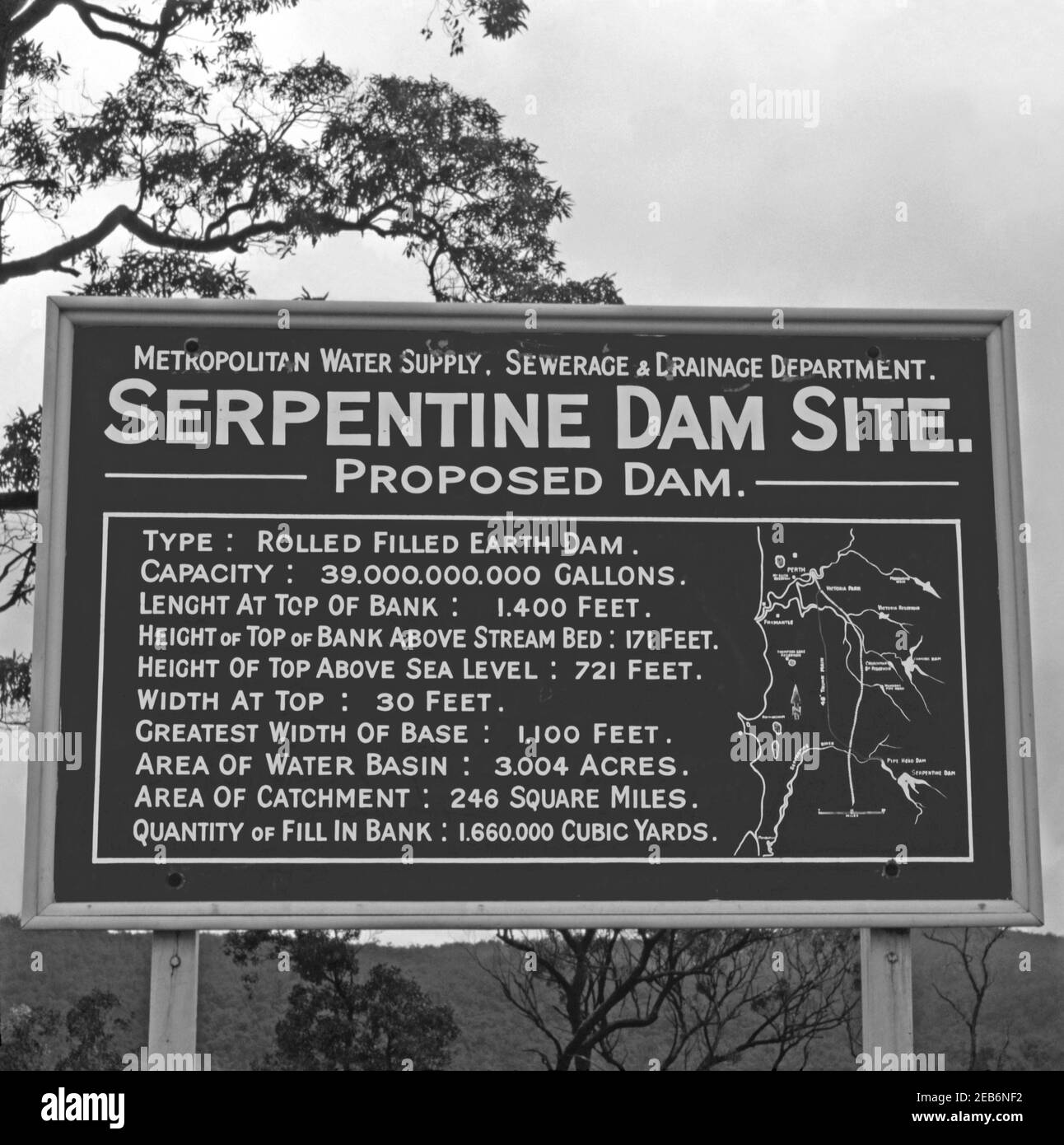 A sign indicating the location of the Sepentine Dam site, Serpentine, Western Australia, Australia c. 1958. Construction of the dam was completed in 1961. The dam’s reservoir is used to store water that is released to feed water to the metropolitan trunk main network. The Serpentine Dam is one of the 15 dams (some of which have since been decommissioned) that were built in WA since the 1920s – part of the Integrated Water Supply Scheme (IWSS), which provides water for over two million people in Perth, Mandurah, and other Western Australian regions. Stock Photo