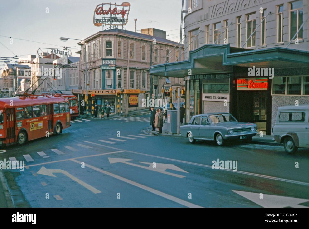 A view at the junction of Willis and Boulcott Streets, Wellington, New Zealand 1969. The trolleybuses see here were big part of the municipal transport system. These electric vehicles operated in Wellington from 1924 until 1932 and again from 1949 until 2017. It was the last trolleybus system operating in the country. The Hotel St George (right) was once one of Wellington’s top hotels. It is an Art Deco building occupying an historic corner site. It was briefly the country's largest hotel. Wellington is the capital city of New Zealand & is located at the south-western tip of the North Island. Stock Photo