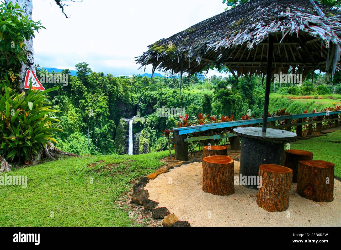 Colourful tropical paradise garden in Oceania, wooden shelter with palm