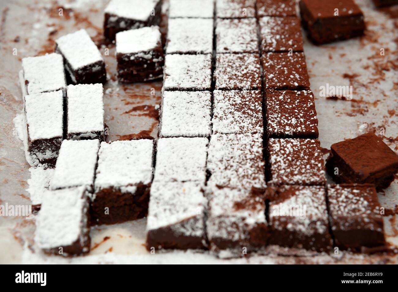 Delicious homemade raw chocolates cut into square shapes sprinkled with powdered sugar. Valentines Day celebration. Stock Photo