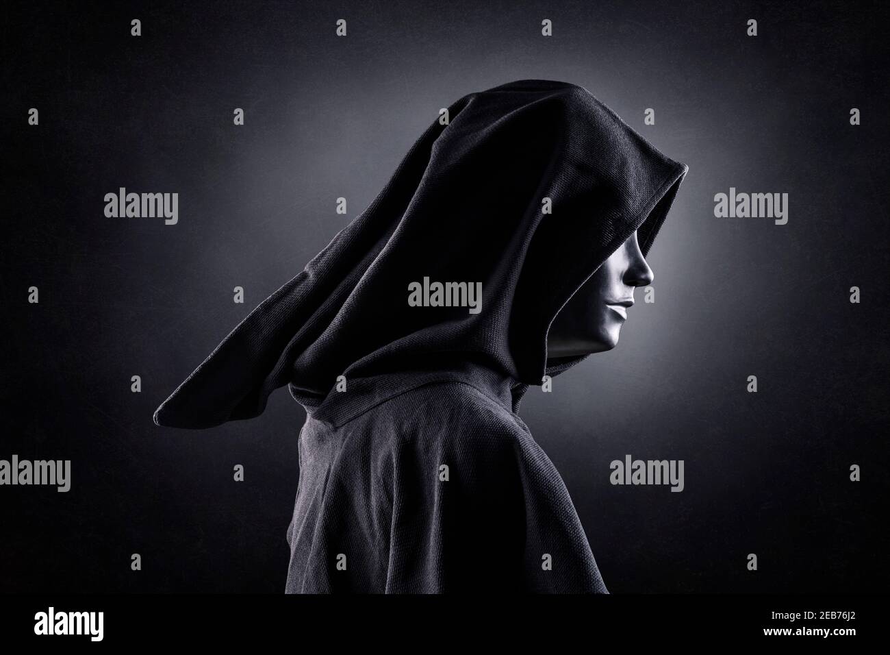 Scary figure with hooded cloak in the dark Stock Photo - Alamy