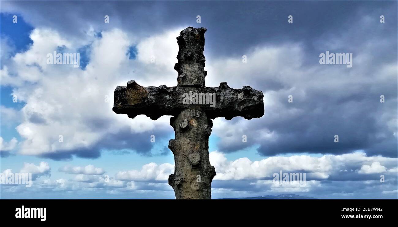 Ancient stone cross against cloudy sky Stock Photo