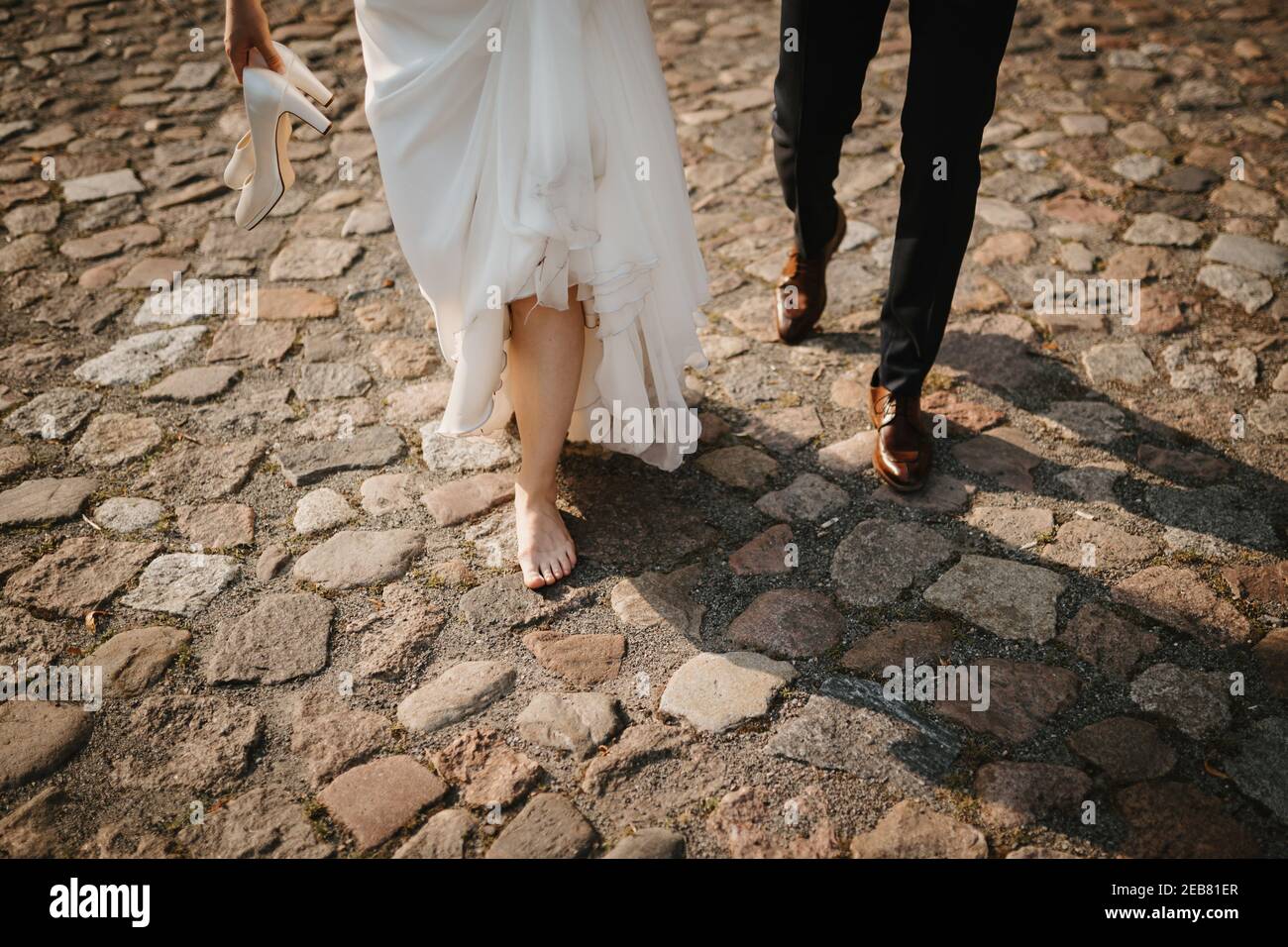 a bride and a groom walking in the street Stock Photo - Alamy