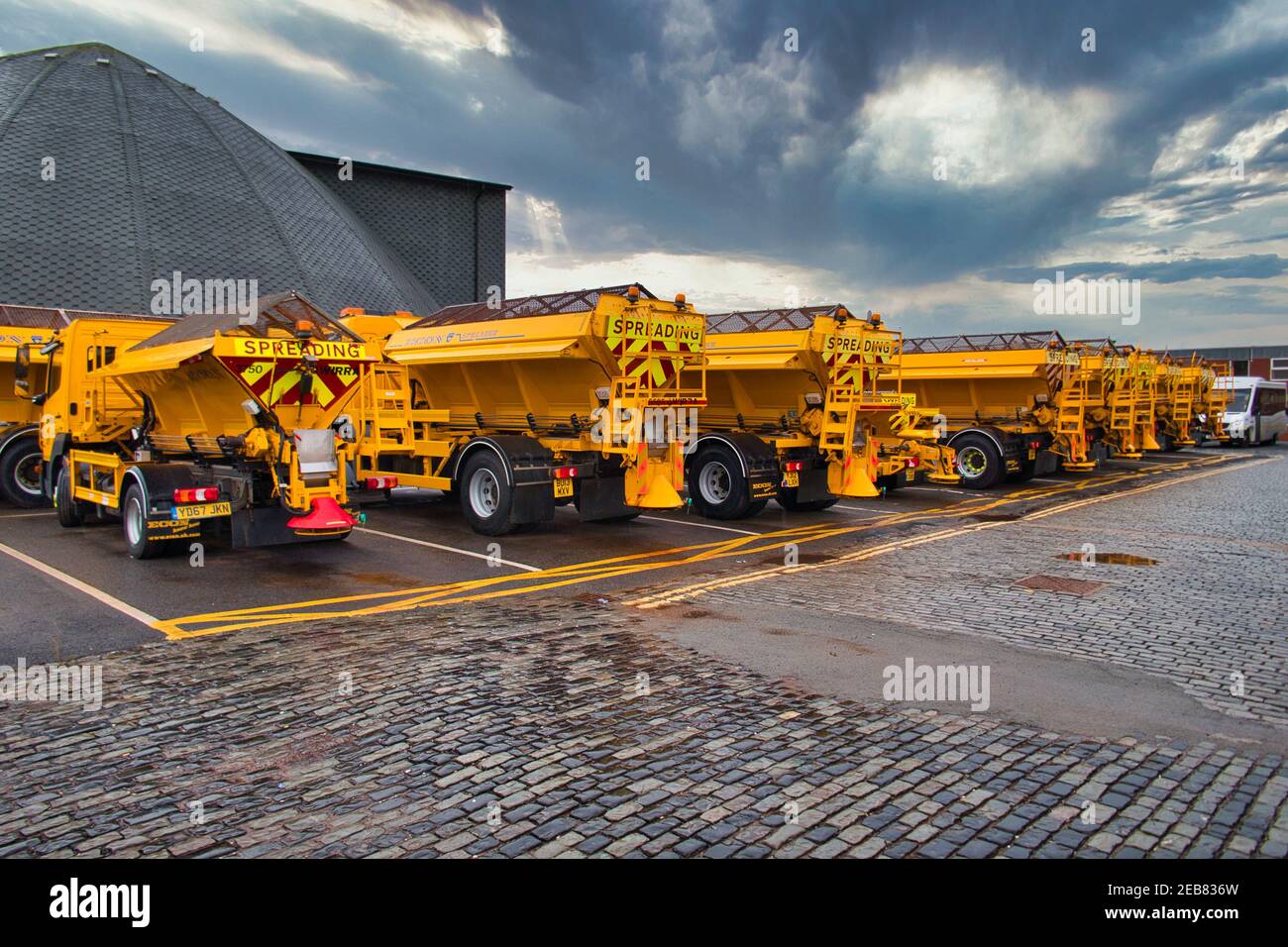 Road gritting equipment in Birkenhead, Wirral, UK. The Wirral Salt Dome is shown on the left - this is where the Council's rock salt supply is stored. Stock Photo
