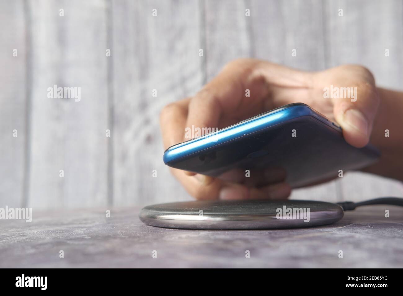 charging Smartphone using Wireless Charging Pad, top view  Stock Photo