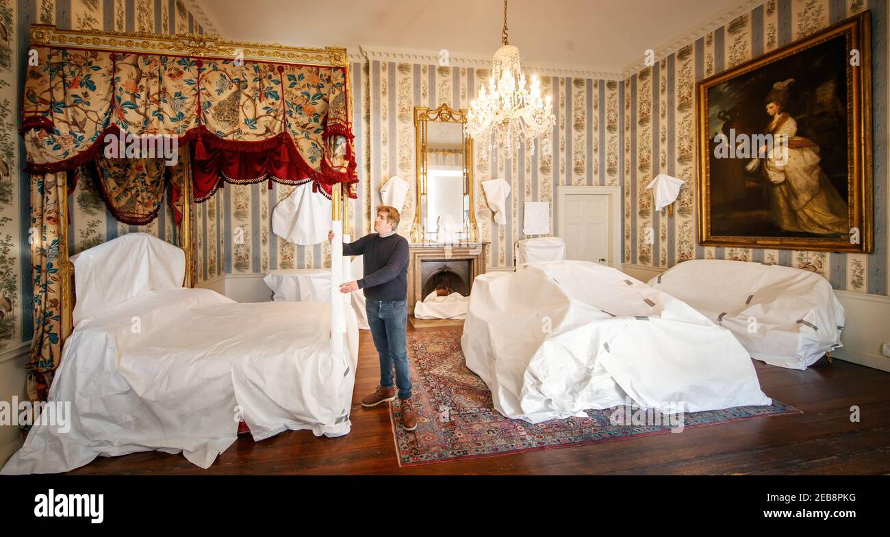Stephen Scholey puts a protective covering over a spectacular golden bed, believed to have been gifted by the Prince of Wales at the beginning of the 1800s, at Temple Newsam House in Leeds. Over the past few weeks, staff at Temple Newsam House have been painstakingly wrapping and covering precious objects in the houseÍs south wing, protecting them while the mansion is closed to the public during lockdown. Picture date: Friday February 12, 2021. Stock Photo