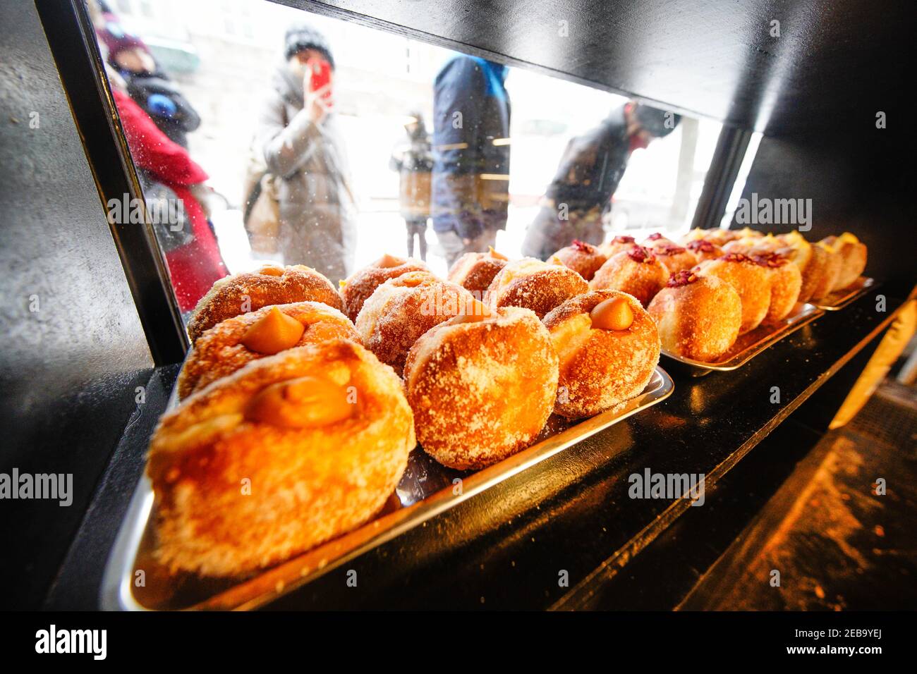 (210212) -- WARSAW, Feb. 12, 2021 (Xinhua) -- Polish fried donuts, or Paczki, are seen in a window display at a bakery in Warsaw, Poland, Feb. 11, 2021. People in Poland eat Paczki, fried donuts filled with cream or jam, on Fat Thursday to mark the last Thursday before the start of Lent. (Photo by Jaap Arriens/Xinhua) Stock Photo