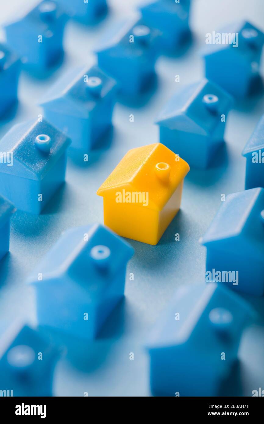 Housing Concept With One Yelllow Plastic House Surrounded By Streets Of Blue Plastic Housing Stock Photo