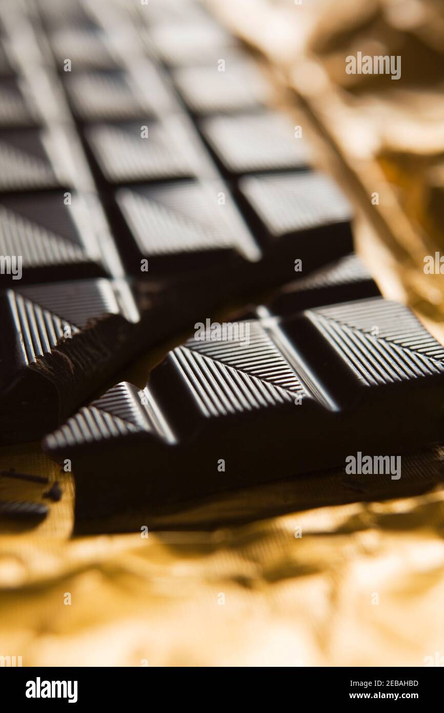 Close Up Of Healthy Dark Chocolate Bar On Gold Foil Stock Photo