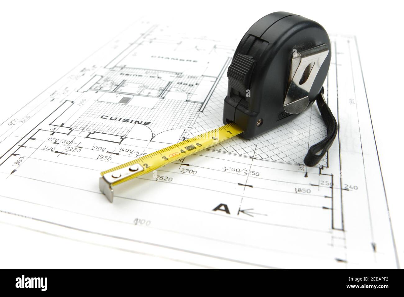 Measuring tape close up on a construction plan isolated on a white background Stock Photo