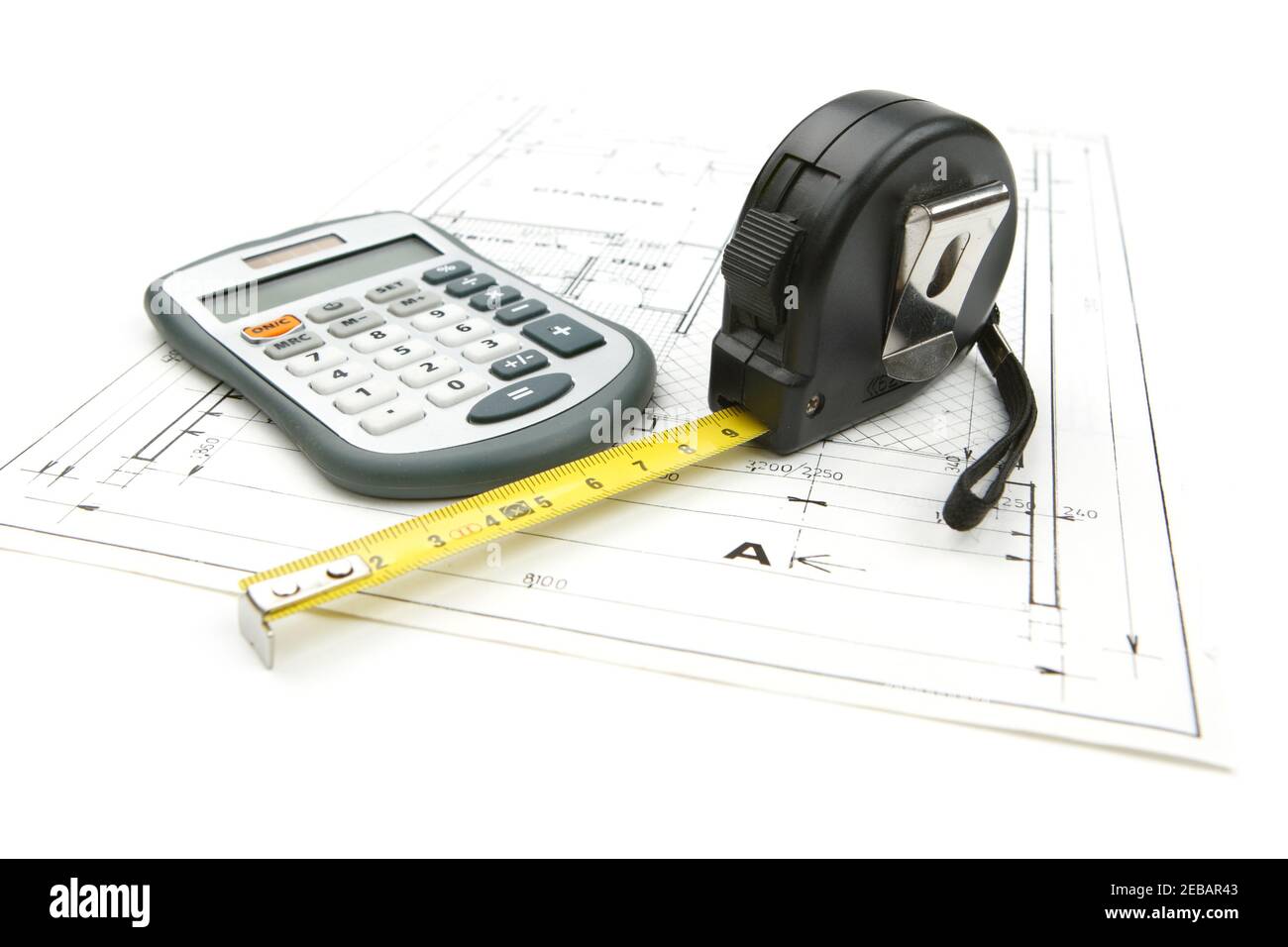 Tape measure with a calculator on the drawing plan of architectural  and construction project, isolated on white background Stock Photo