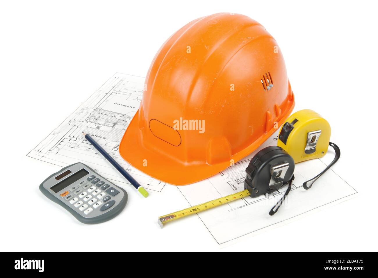 Concept of architecture and construction of the building with hard hat posed on paper plans, tape measures, a pencil and a calculator. photo shooting Stock Photo