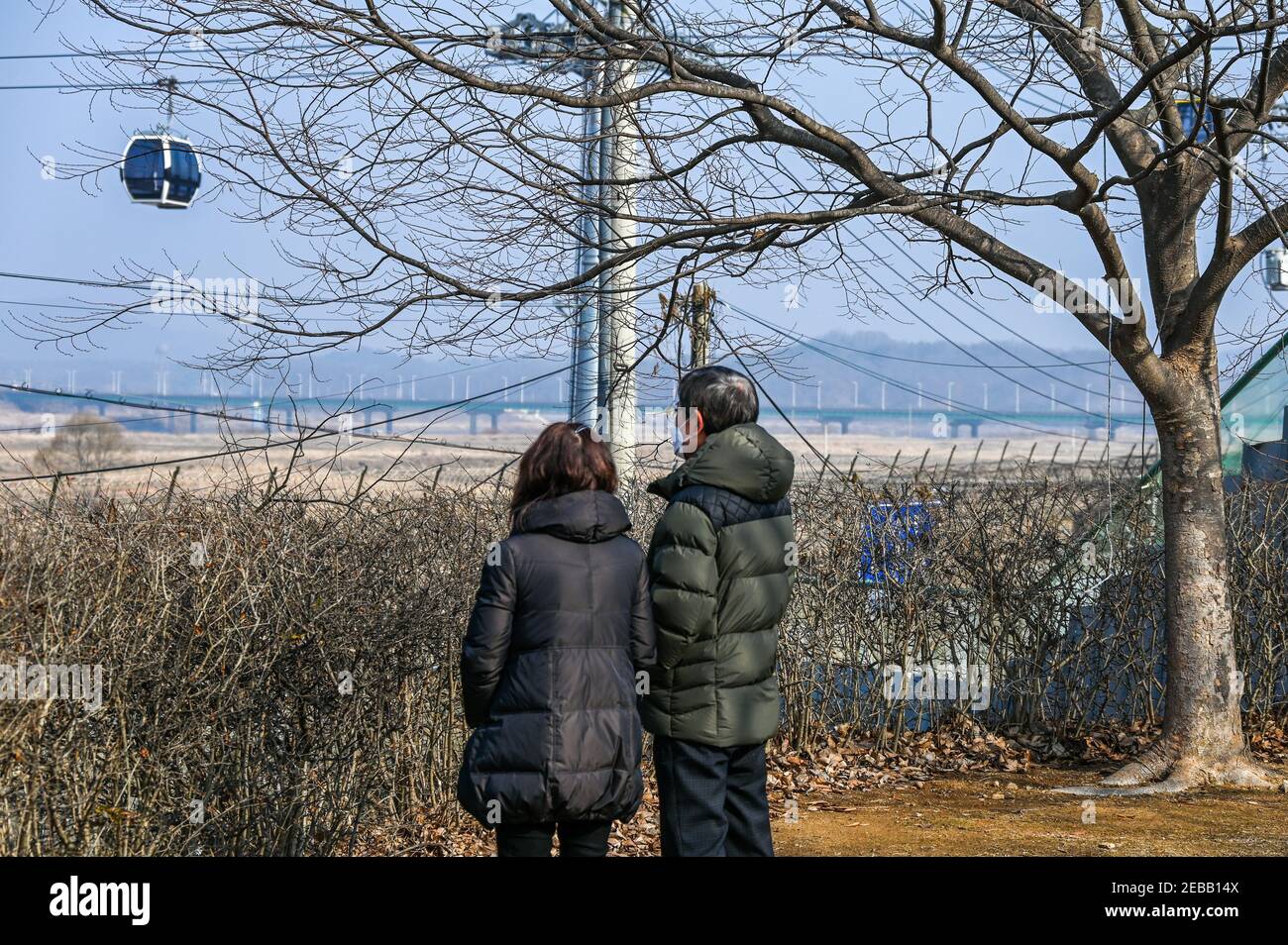 Paju, South Korea. 12th Feb, 2021. Members of Korean separated families look across the border to the North on Lunar New Year near the DMZ at Imjingak Park in Paju, South Korea on February 12, 2021. In the background is a new gondola system that crosses the Imjin River. Photo by Thomas Maresca/UPI Credit: UPI/Alamy Live News Stock Photo