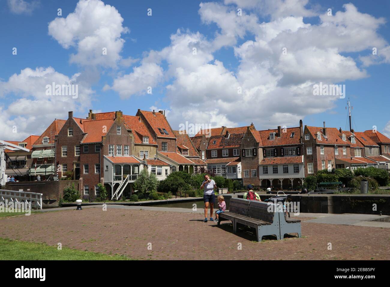 Tourist family having icecream in historic center at harbour with old houses in Enkhuizen, Noord-Holland, the Netherlands, June 2020 Stock Photo