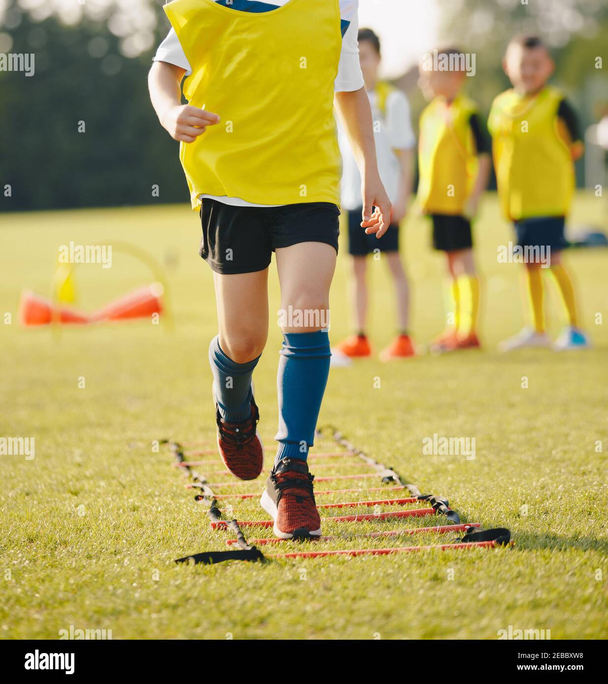 Children Running on Ladder Training Drill. Beginner Football Agility Ladder Drills. Happy Kids on Sports Summer Camp Stock Photo