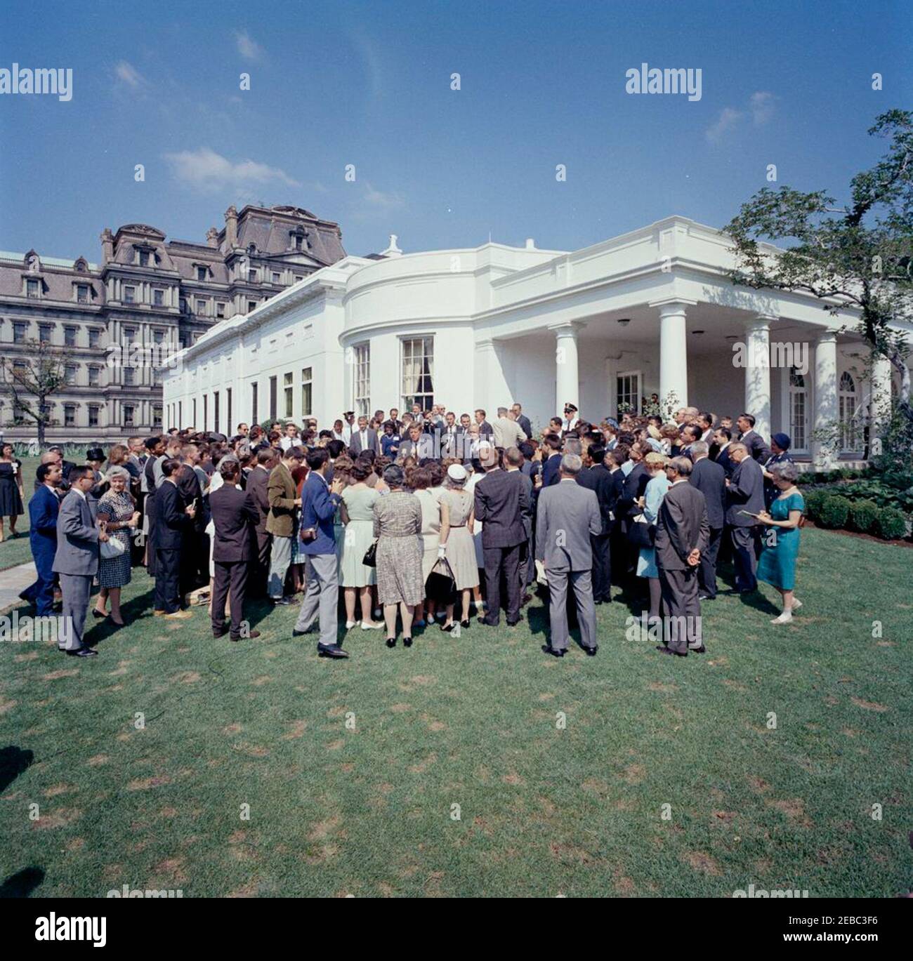 Visit of international representatives of the Jr. Red Cross, 11:00AM. President John F. Kennedy (center) delivers remarks to international representatives of the Junior Red Cross on the West Wing Lawn. Also pictured: Special Assistant to the President, Dave Powers; President of the American Red Cross, General Alfred M. Gruenther; National Park Service (NPS) photographer, Abbie Rowe; White House Secret Service agents, Walt Coughlin, Don Lawton, and Stu Stout. White House, Washington, D.C. Stock Photo