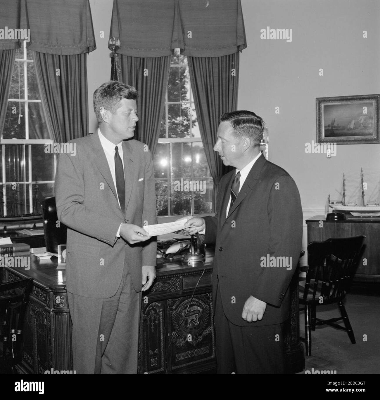 Ceremony beginning the Greater Boston United Fund Drive, 10:25AM. President John F. Kennedy presents a contribution to William H. Claflin, III, of the Greater Boston United Fund, to initiate the organizationu2019s 1963 fundraising campaign. Oval Office, White House, Washington, D.C. Stock Photo
