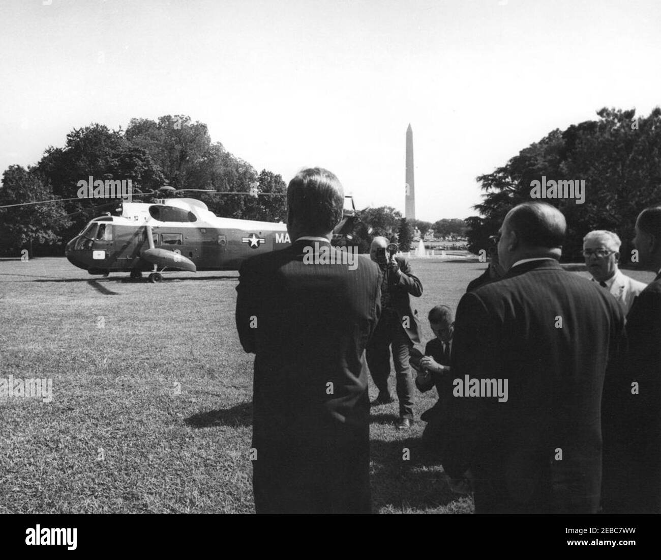 Ceremony marking Vice President Lyndon B. Johnsonu0027s (LBJ) departure on a good-will trip, 3:30PM. President John F. Kennedy watches as Vice President Lyndon B. Johnsonu2019s helicopter prepares to depart the South Lawn for his good-will trip to Lebanon, Iran, Turkey, Greece, Cyprus, and Italy. Ambassador of Nicaragua and Dean of the Diplomatic Corps, Dr. Guillermo Sevilla-Sacasa, stands at right (back to camera); unidentified photographers and reporters observe. White House, Washington, D.C. Stock Photo