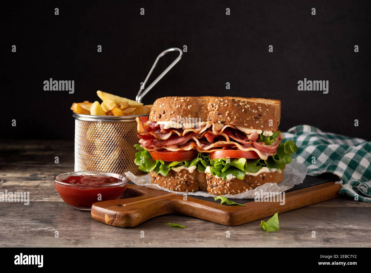 BLT sandwich and fries on wooden table Stock Photo