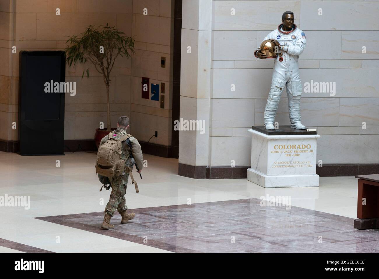 Washington, United States Of America. 12th Feb, 2021. A member of the National Guard walks near the statue of Apollo 13 astronaut Jack Swigert, who was also elected to Congress from Colorado but never served, in the Capitol Hill Visitors Center in Washington, DC, February 12, 2021.Credit: Chris Kleponis - Pool via CNP | usage worldwide Credit: dpa/Alamy Live News Stock Photo