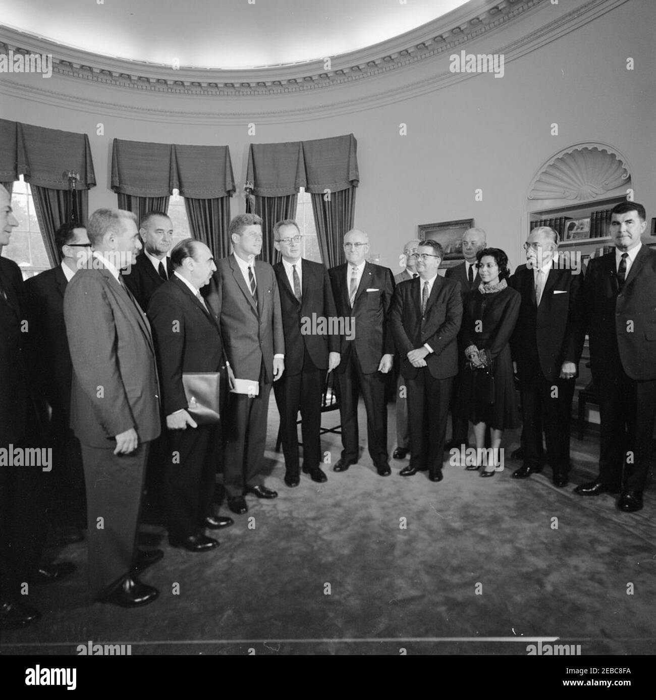 Meeting with the National Advisory Committee on Manpower Development and Training, 1:10PM. President John F. Kennedy meets with members of the National Advisory Committee on Manpower Development and Training. Left to right: Executive Vice President of W. R. Grace and Company, Felix E. Larkin (partially hidden on edge of frame); Deputy Assistant Secretary of Labor for Employment and Manpower, Seymour L. Wolfbein (face obscured); Chairman of the Committee and Director of the Conservation of Human Resources Project at Columbia University, Dr. Eli Ginzberg; Vice President Lyndon B. Johnson; Secret Stock Photo
