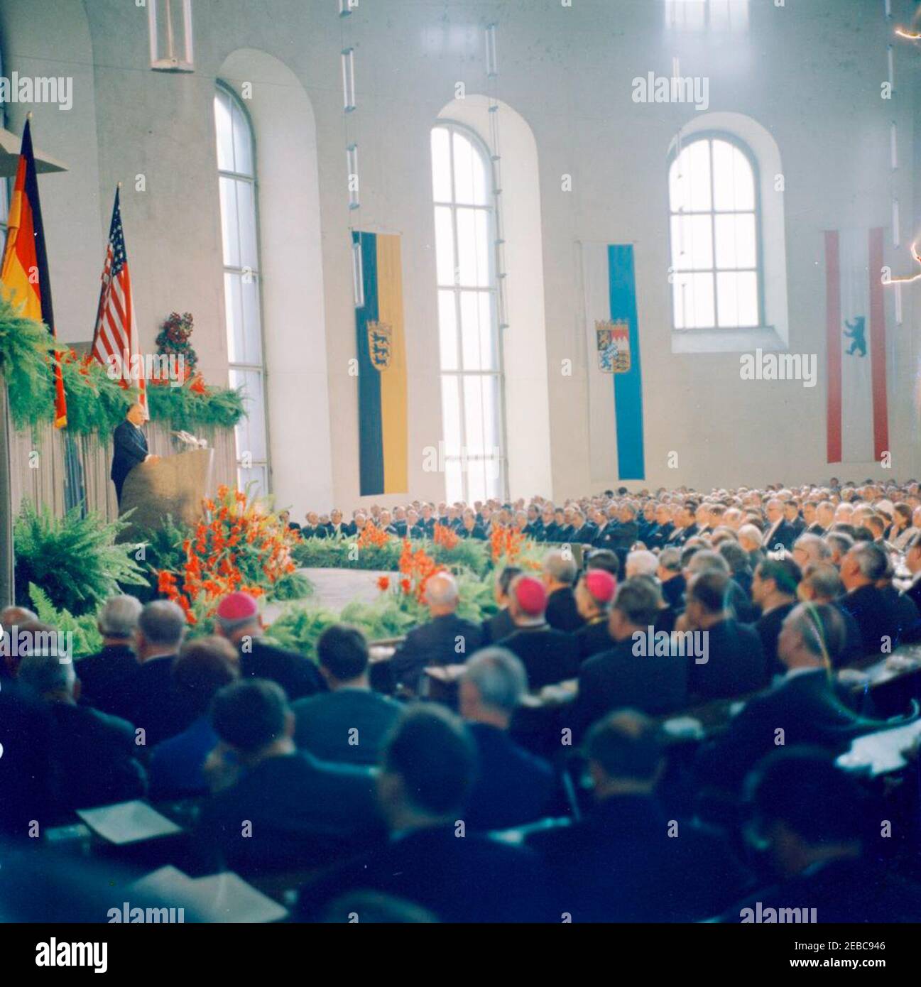 Trip to Europe: Germany, Frankfurt: President Kennedy at Paulskirche, 4:35PM. President John F. Kennedy (seated at right) visits Paulskirche (St. Paulu2019s Church) in Frankfurt am Main, West Germany (Federal Republic); President of the Bundestag, Eugen Gerstenmaier (at lectern), delivers remarks for the occasion. [Blemishes along right edge are original to the negative.] Stock Photo