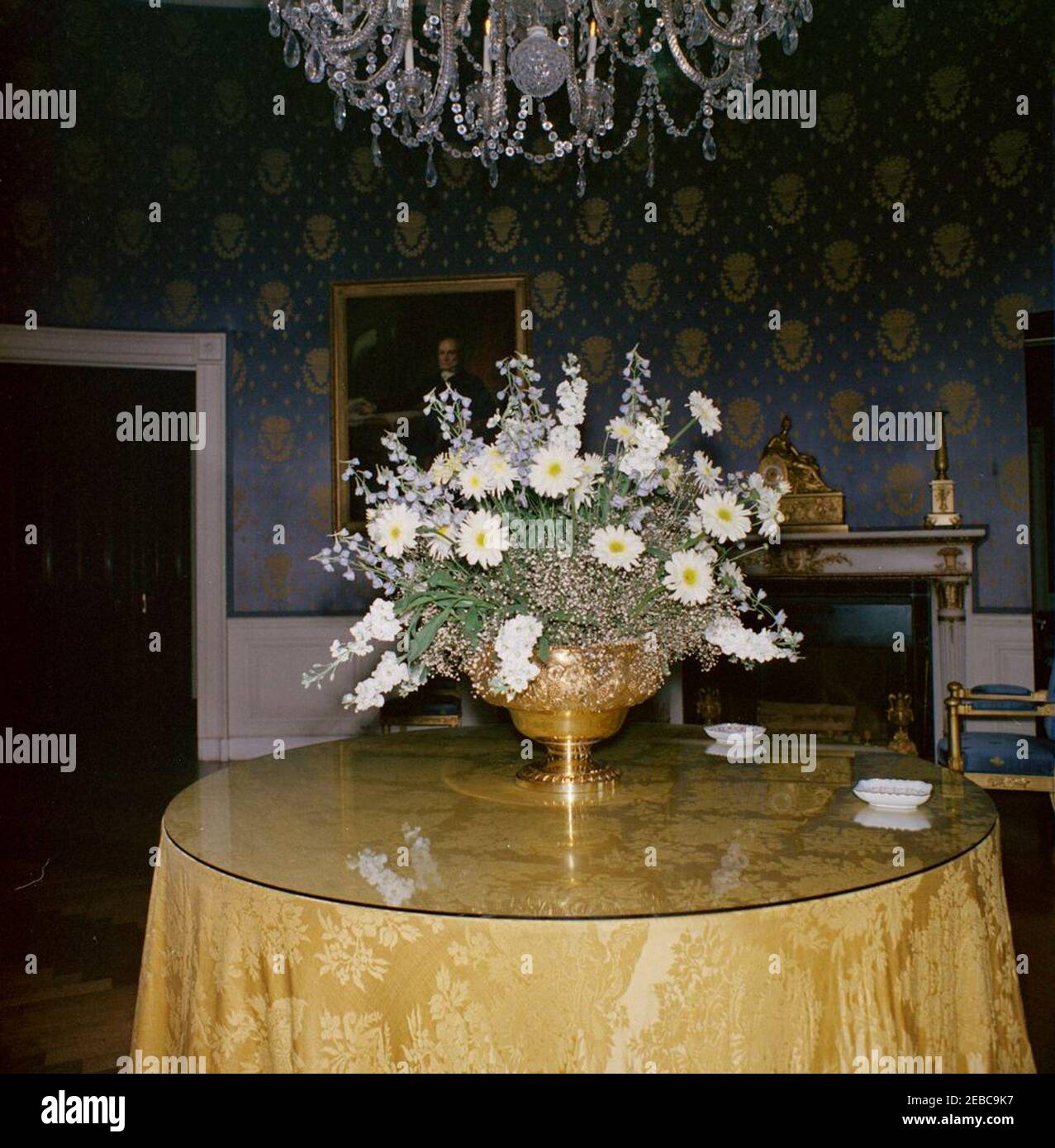 Luncheon in honor of Harold Macmillan, Prime Minister of Great Britain, 1:00PM (settings and flowers). View of a flower arrangement in the Blue Room of the White House, Washington, D.C., set up for a luncheon in honor of Prime Minister of Great Britain, Harold Macmillan. A portrait of John Quincy Adams by George P. A. Healy hangs on wall. Stock Photo