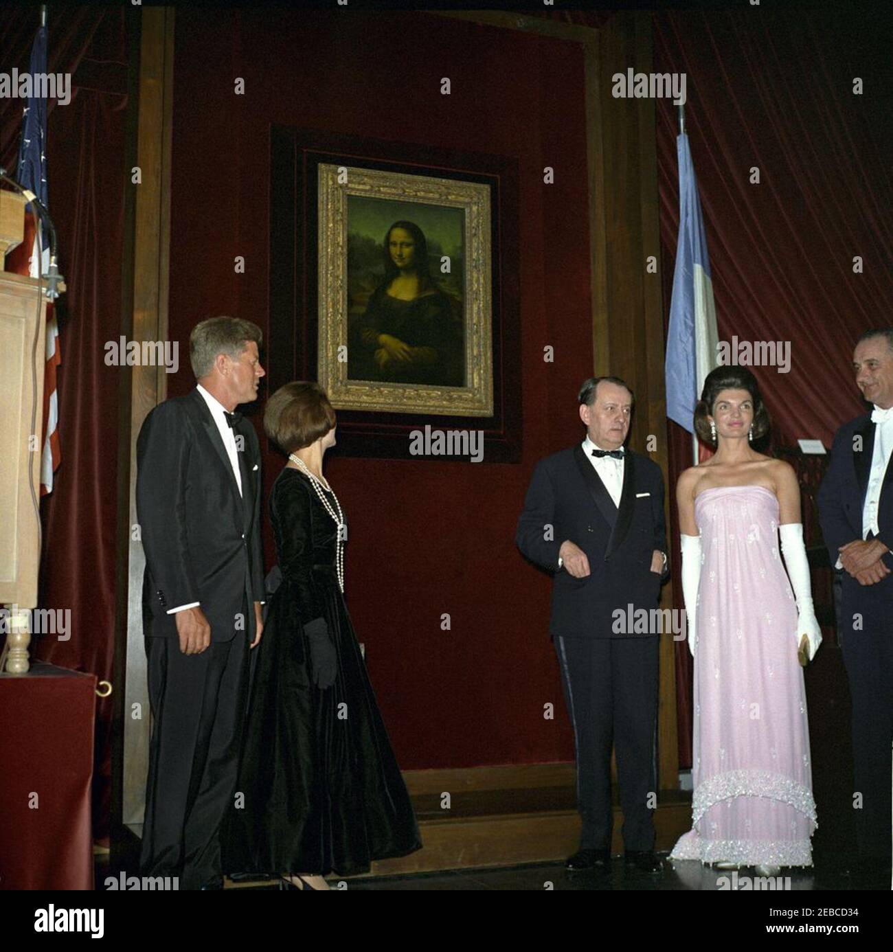Opening ceremony, Mona Lisa Exhibit at the National Gallery of Art, President Kennedy and First Lady Jacqueline Kennedy (JBK), 10:00PM. President John F. Kennedy and First Lady Jacqueline Kennedy stand before the Mona Lisa at the opening of a temporary exhibition of the painting at the National Gallery of Art, Washington, D.C. (L-R) President Kennedy; pianist Madeleine Malraux (wife of Minister of State for Cultural Affairs of France, Andru00e9 Malraux); Minister Malraux; First Lady Jacqueline Kennedy; Vice President Lyndon Johnson. Stock Photo