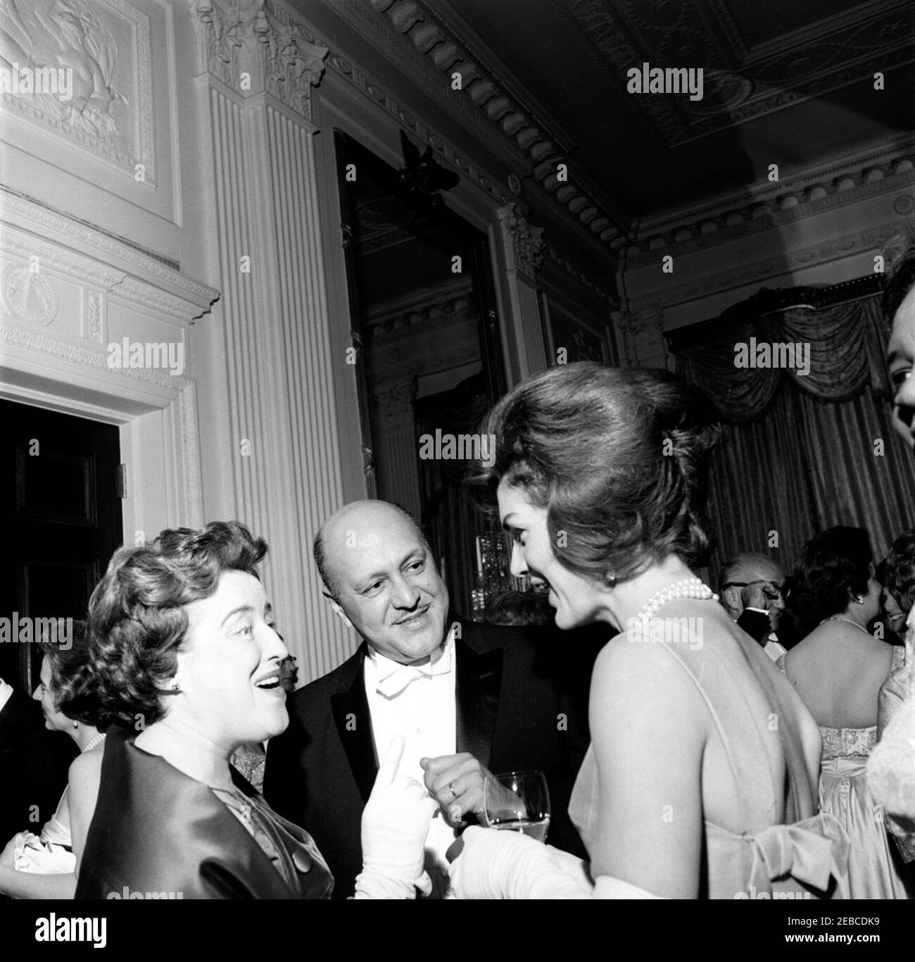 Dinner in honor of Vice President Lyndon B. Johnson (LBJ), Speaker of the House John W. McCormack, u0026 Chief Justice Earl Warren, 8:00PM. First Lady Jacqueline Kennedy (right) visits with Administrator of the Housing and Home Finance Agency Robert C. Weaver (center) and his wife Dr. Ella Haith Weaver at a dinner in honor of Vice President Lyndon B. Johnson, Speaker of the House of Representatives John W. McCormack, and Supreme Court Chief Justice Earl Warren. East Room, White House, Washington, D.C. Stock Photo