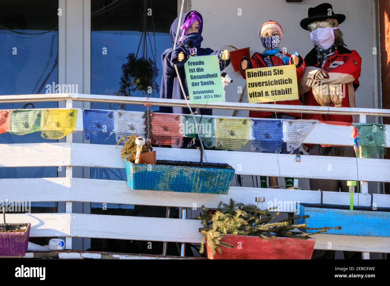 Sythen, Münsterland, NRW, 12th Feb 2021. A family have put up a scene with dressed shop dummies wearing face masks and positive messages of encouragement to 'stay optimistic' on their balcony in the small village of Sythen near Haltern-am-See in North Rhine-Westphalia. Credit: Imageplotter/Alamy Live News Stock Photo