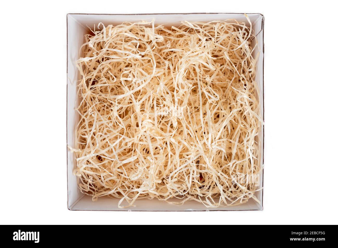 Opened gift box with decorative straw, filler, shavings. Top view