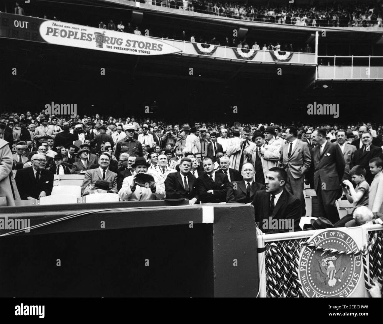Opening Day at D.C. Stadium, 1962 Baseball Season, 2:00PM. President John F. Kennedy talks with Senator George Smathers of Florida (right of President Kennedy) during the opening game of the 1962 baseball season. Special Assistant to the President Dave Powers sits left of the President, holding up a baseball glove. Others pictured include: Representative Carroll D. Kearns of Pennsylvania; Representative Hale Boggs of Louisiana; Secretary of Labor Arthur J. Goldberg; Special Assistant to the President Lawrence u201cLarryu201d Ou2019Brien; Special Assistant to the President Timothy Reardon; S Stock Photo