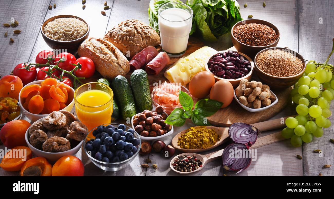 Composition with assorted organic food products on wooden kitchen table ...