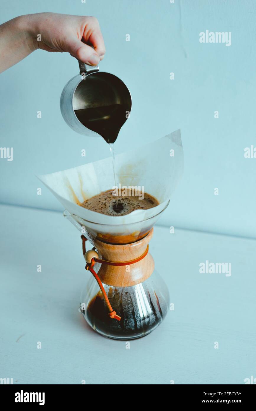 Hand pouring hot water into a coffeemaker Stock Photo Alamy