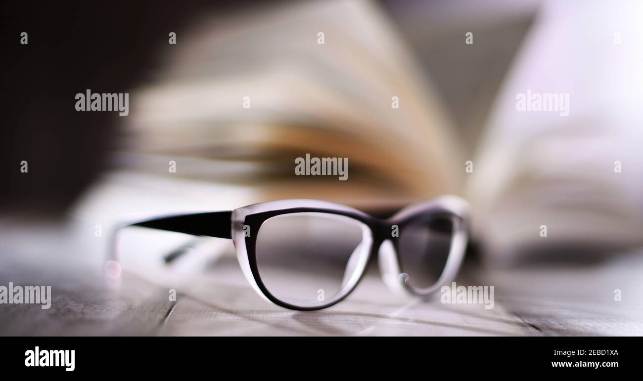 Composition with glasses and open book on the table. Stock Photo
