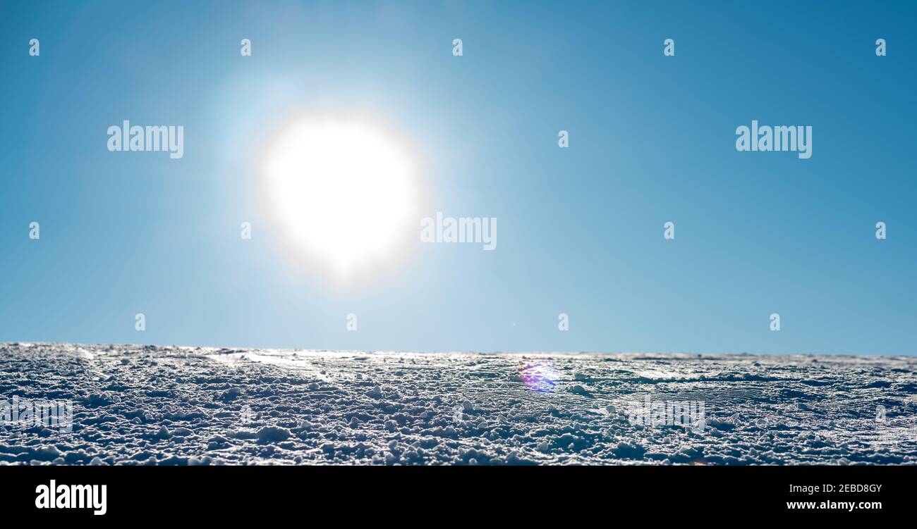 Close up of a ski resort slope with packed snow and bright sunshine. Stock Photo