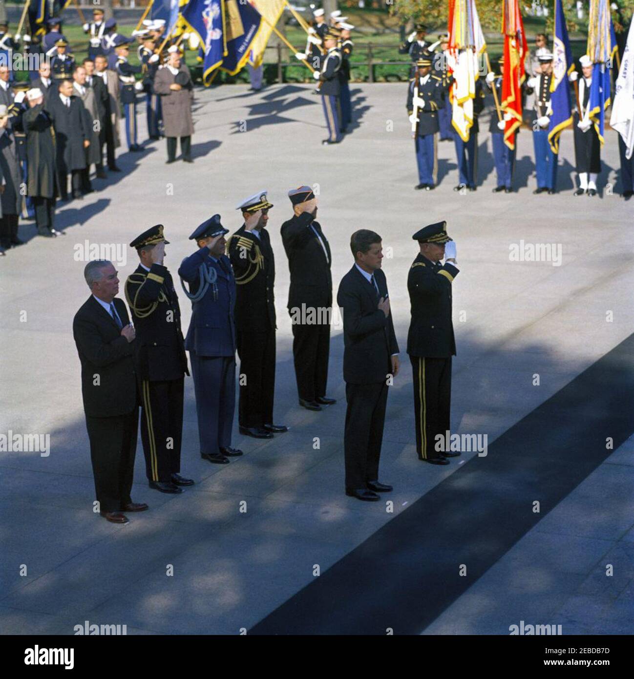 Address at Veterans Day Ceremonies, Arlington National Cemetery, 11:01AM. President John F. Kennedy participates in Veterans Day ceremonies. President Kennedy stands with Major General Paul A. Gavan, Commanding General of the Military District of Washington. Standing behind the President (L-R): John S. Gleason, Administrator of Veterans Affairs; Military Aide to the President General Chester V. Clifton; Air Force Aide to the President Colonel Godfrey T. McHugh; Naval Aide to the President Captain Tazewell T. Shepard; and Thomas Stirling, National Commander of the Legion of Valor. Arlington Nat Stock Photo