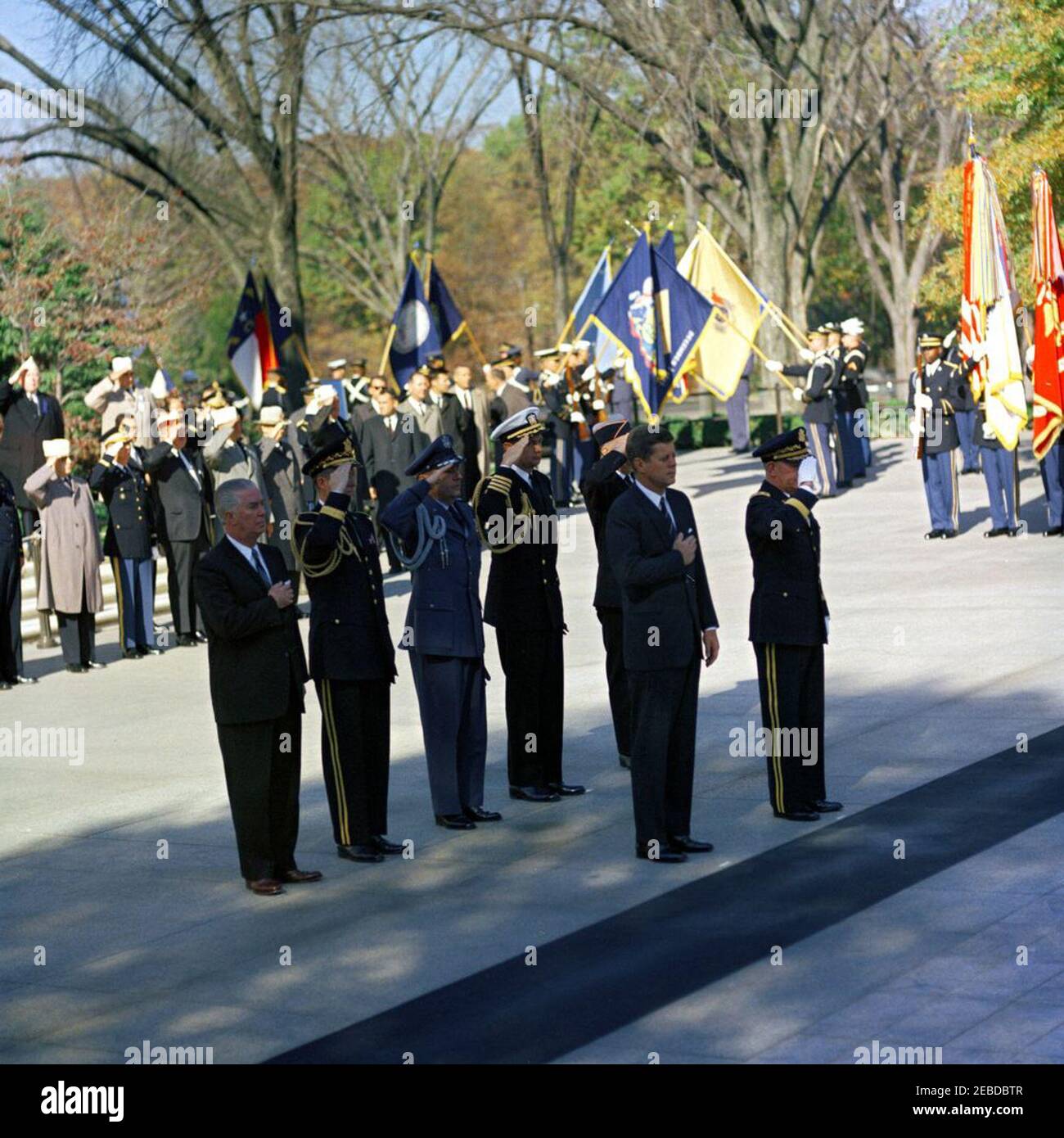 Address at Veterans Day Ceremonies, Arlington National Cemetery, 11:01AM. President John F. Kennedy participates in Veterans Day ceremonies. President Kennedy stands with Major General Paul A. Gavan, Commanding General of the Military District of Washington. Standing behind the President (L-R): John S. Gleason, Administrator of Veterans Affairs; Military Aide to the President General Chester V. Clifton; Air Force Aide to the President Colonel Godfrey T. McHugh; Naval Aide to the President Captain Tazewell T. Shepard; and Thomas Stirling, National Commander of the Legion of Valor (partially hid Stock Photo