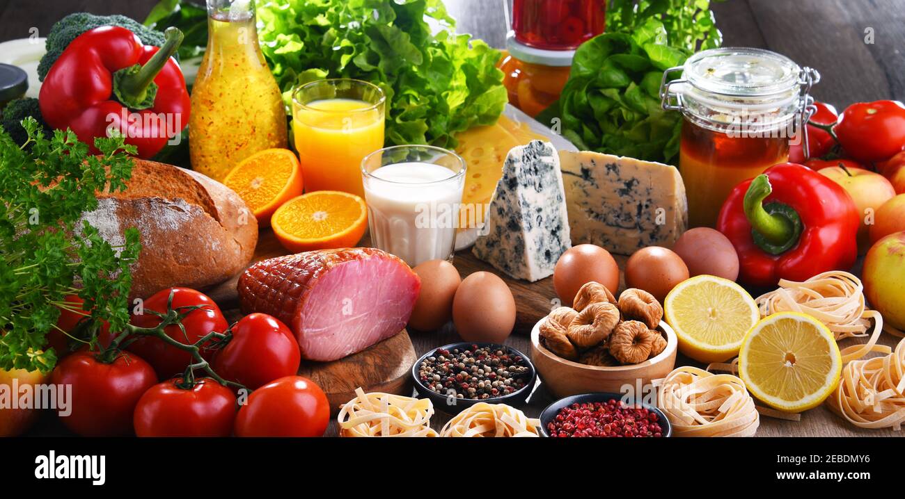 Assorted organic food products on wooden kitchen table Stock Photo - Alamy