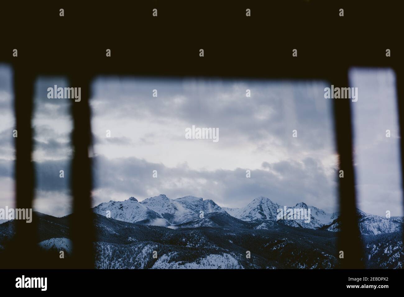 Looking at snow covered mountains through cabin window Stock Photo